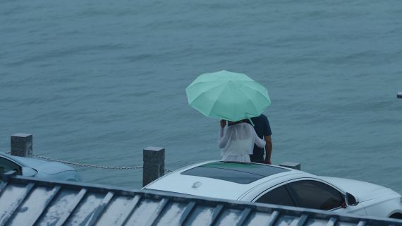 雨天撑伞的海边的夫妻